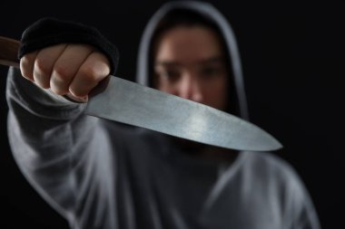 Siyah arka planda bıçaklı suçlu, seçici odaklı