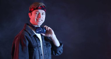 Karanlık arka planda dumanlı kulaklık takan bir adam. Metin için boşluk