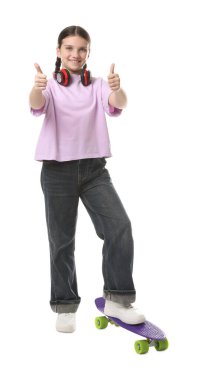 Kulaklıkları ve para tahtasıyla beyaz arka planda baş parmağını gösteren hoş bir kız.