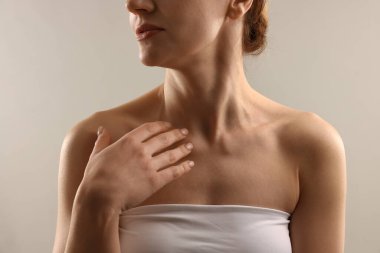 Açık gri arka planda normal ciltli kadın, yakın plan.