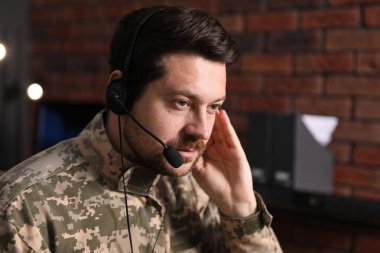 Askerlik. Ofiste çalışan kulaklıklı asker, metin için alan