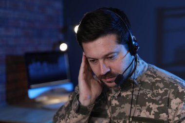 Askerlik. Kulaklıklı asker gece ofiste çalışıyor, mesaj için yer var.