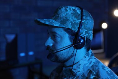 Askerlik. Kulaklıklı asker gece ofiste çalışıyor, mesaj için yer var.