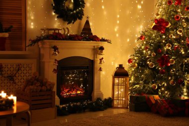 Güzel bir şömine, Noel ağacı ve karanlık odada şenlikli bir dekor. İç tasarım