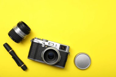Sarı arka planda profesyonel fotoğrafçı ekipmanı var. Metin için boşluk