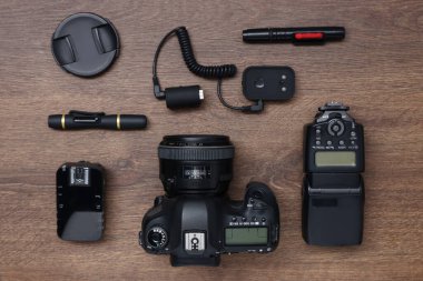 Profesyonel fotoğrafçı ekipmanları ahşap masada, düz yerde.