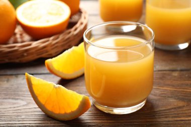 Taze portakal suyu ve ahşap masada meyveler, yakın plan.