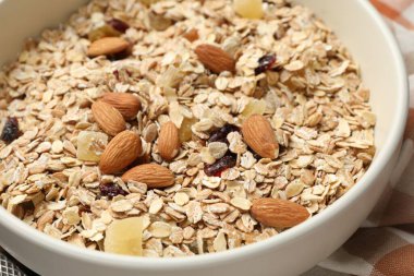 Tahıl yapıyorum. Yulaf gevreği, kurutulmuş meyve ve badem fıstığı masada, yakın plan.