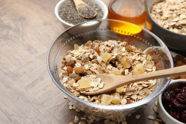 Tahıl yapıyorum. Tahta masada kurumuş meyveli yulaf gevrekleri, yakın plan. Metin için boşluk