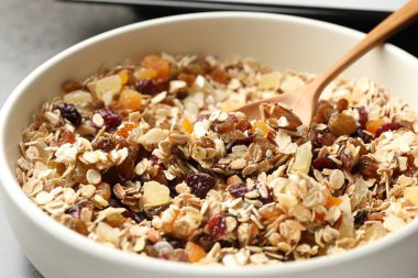 Tahıl yapıyorum. Yulaf ezmeli kase, bal ve kurutulmuş meyveler masada, yakın plan.