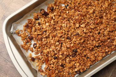 Tahta sehpanın üzerinde kurumuş meyveli leziz granola.