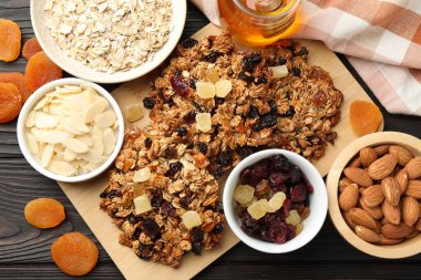 Kurumuş meyveli ve fındıklı lezzetli granola barları, siyah ahşap masa, düz uzanmış