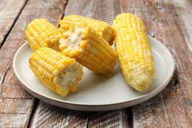 Ahşap masada haşlanmış mısır koçanları, yakın plan.