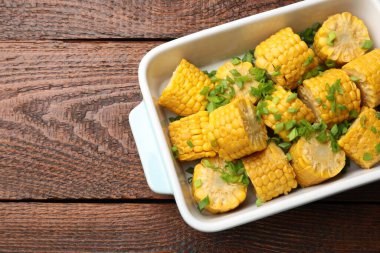 Ahşap masada yeşil soğanlı haşlanmış mısır koçanı parçaları, üst manzara. Metin için boşluk