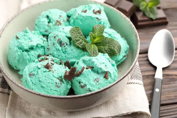 Ahşap masada sunulan yapraklı naneli çikolatalı dondurma.