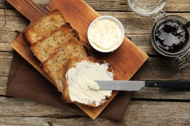 Tahta masada kızarmış ekmek, tereyağı ve reçel.