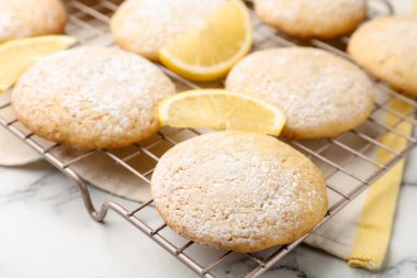 Lezzetli limonlu kurabiyeler ve beyaz mermer masada meyve dilimleri, yakın plan.