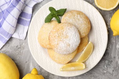 Lezzetli limonlu kurabiyeler ve gri masada meyve dilimleri.