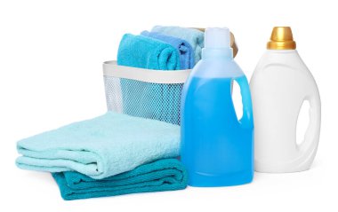 Çamaşır sepeti, yumuşak havlular ve beyaza izole edilmiş deterjan şişeleri.