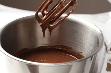 Çikolata hamuru mikserden kaseye damlıyor, yakın plan.