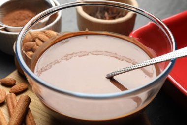 Tabakta sıvı çikolata hamuru, baharatlar, fındık ve kakao tozu, yakın plan.