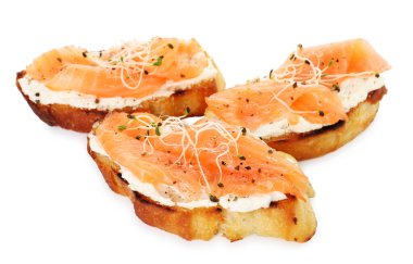 Somon, krem peynir ve beyaz üzerine izole edilmiş mikro sebzeli lezzetli bruschettalar.