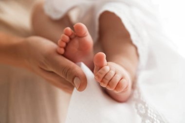 Vaftiz ayini. Küçük bebeği kucağında tutan kadın, yakın plan.