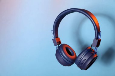 Açık mavi arkaplanda havalı kulaklıklar, metin için boşluk