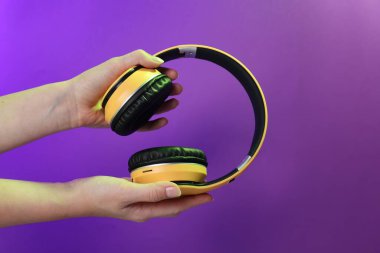 Mor arka planda şık kulaklıklı kadın, yakın plan.