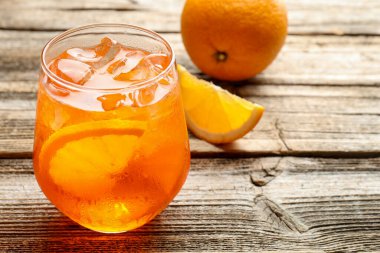 Bir bardak serinletici spritzer kokteyli ve portakallar ahşap masada, yakın plan.