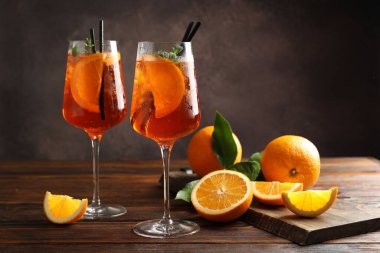Serinletici spritzer kokteyli ve portakallar ahşap masada.