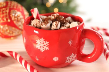 Marşmelovlu lezzetli kakao, baston şekerler ve ahşap masada Noel dekoru, yakın plan.