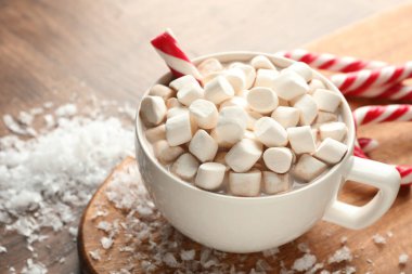 Noel atmosferi. Marşmelovlu lezzetli kakao ve tahta masada şeker kamışı, yakın plan. Metin için boşluk
