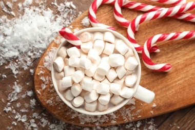 Noel atmosferi. Lezzetli kakao, marşmelov ve baston şeker, ahşap masa, üst manzara.