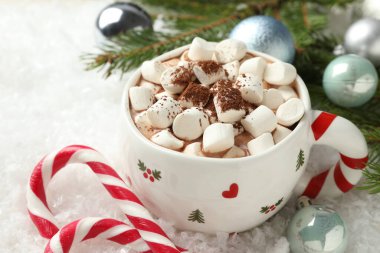 Marşmelovlu lezzetli kakao, baston şekerler ve yapay kar üzerine Noel dekoru, yakın plan.
