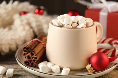 Marşmelovlu lezzetli kakao, baston şekerler, tarçın ve Noel süsü ahşap masada, yakın plan.