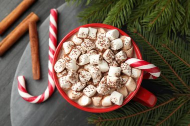 Lezzetli kakao, lokum, şeker kamışı, tarçın ve Noel süsü siyah masada, düz yerde.