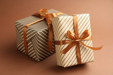 Kahverengi arka planda güzel paketlenmiş hediyeler, yakın plan