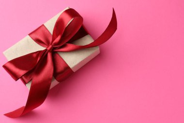 Pembe arka planda fiyonklu güzel bir hediye, üst manzara. Metin için boşluk