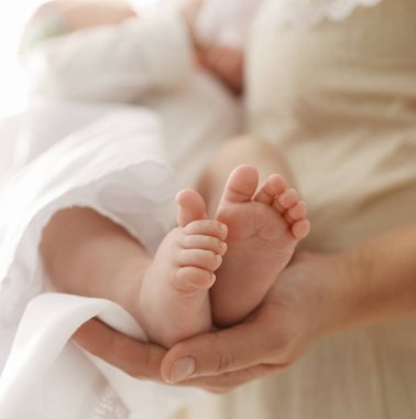 Vaftiz ayini. Küçük bebeği kucağında tutan kadın, yakın plan.