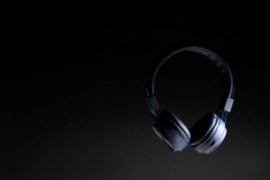 Siyah arkaplanda havalı kulaklıklar, metin için boşluk