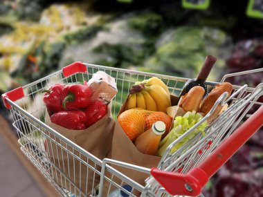 Süpermarketteki ürünlerle dolu alışveriş arabası.