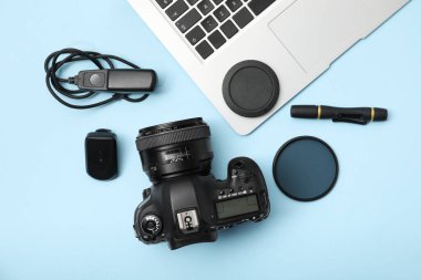 Açık mavi zemin üzerinde profesyonel fotoğrafçı ekipmanı, düz yatıyordu