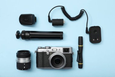 Açık mavi zemin üzerinde profesyonel fotoğrafçı ekipmanı, düz yatıyordu