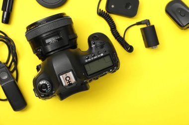 Sarı arka planda profesyonel fotoğrafçı ekipmanı var.