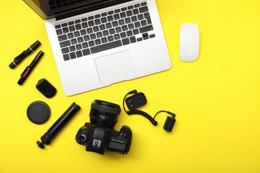 Sarı arka planda profesyonel fotoğrafçı ekipmanı var.
