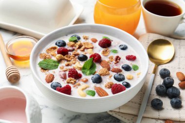 Sağlıklı kahvaltı. Fındıklı yulaf ezmesi, böğürtlen ve süt beyaz mermer masada, yakın plan.