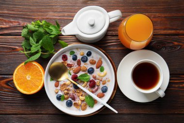 Sağlıklı kahvaltı. Fındıklı yulaf ezmesi, böğürtlen ve süt kasede ahşap masada servis edilir.