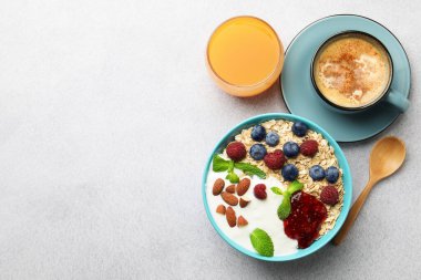 Sağlıklı kahvaltı. Fındıklı yulaf ezmesi, böğürtlen, yoğurt, reçel, kahve ve meyve suyu. Metin için boşluk