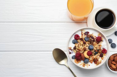 Sağlıklı kahvaltı. Fındıklı yulaf ezmesi, böğürtlen ve süt beyaz ahşap masada servis edilir. Metin için boşluk